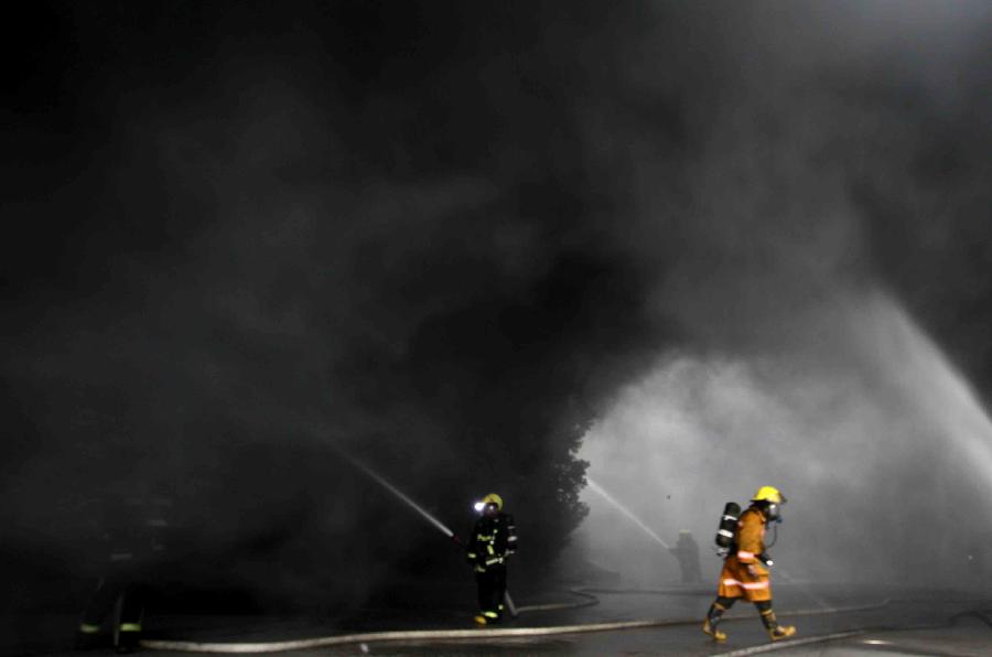 1月21日，消防员在浙江平湖箱包厂火灾现场灭火。