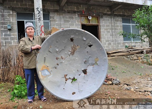 忻城县北更乡犀牙村村民展示被冰雹打烂的“村村通”小锅盖。通讯员樊绍光 摄